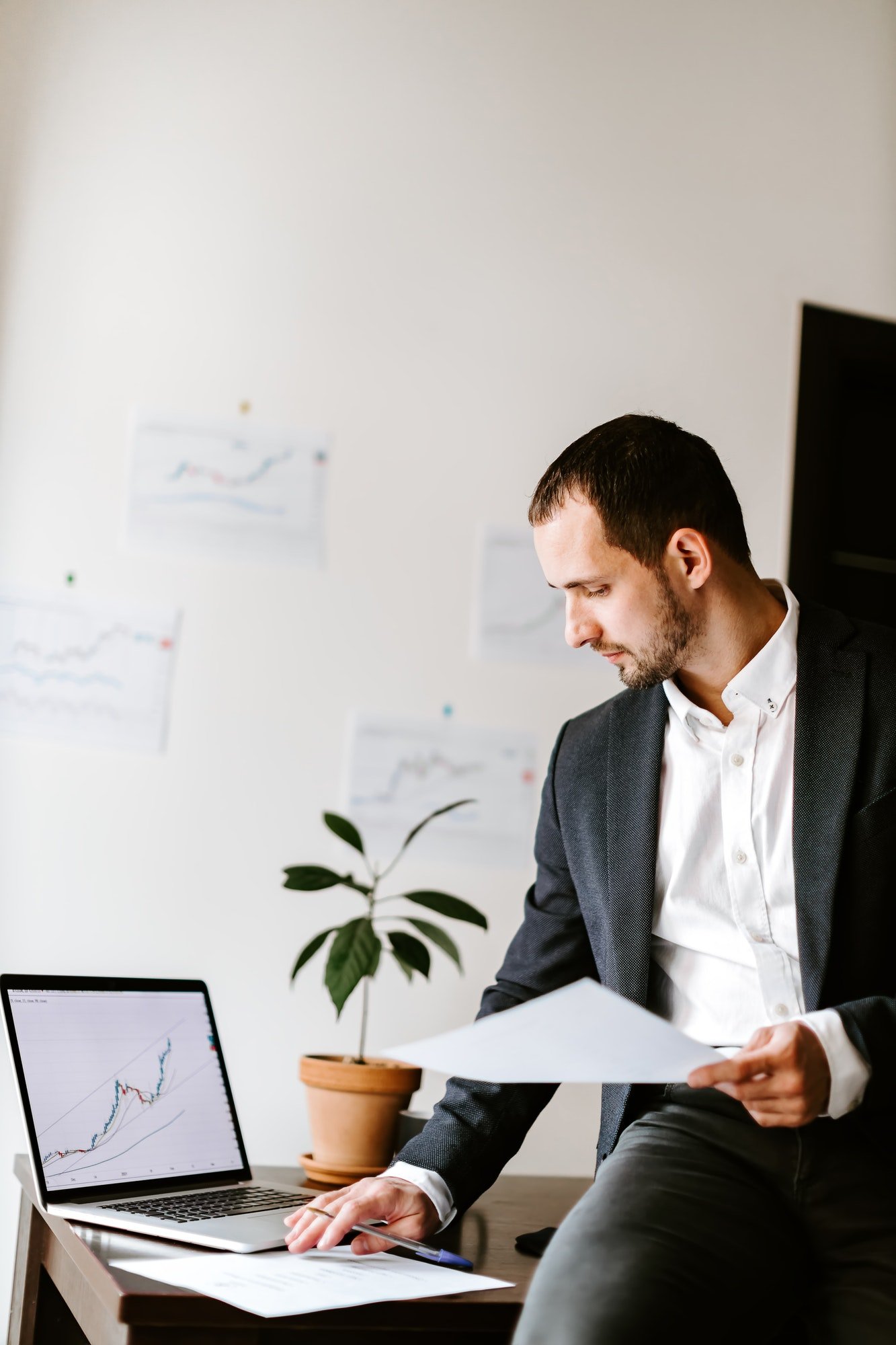 investment advisor analyzing price data trend graph on laptop in office