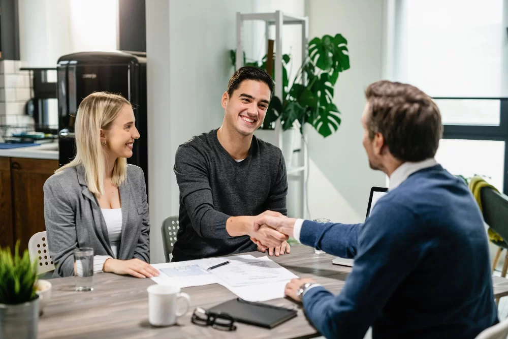 Investment advisor shaking hands with his client while a girl watches