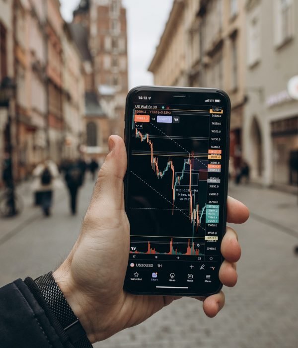 A smartphone showing a financial trading app with live charts, highlighting the journey to financial freedom through investing.