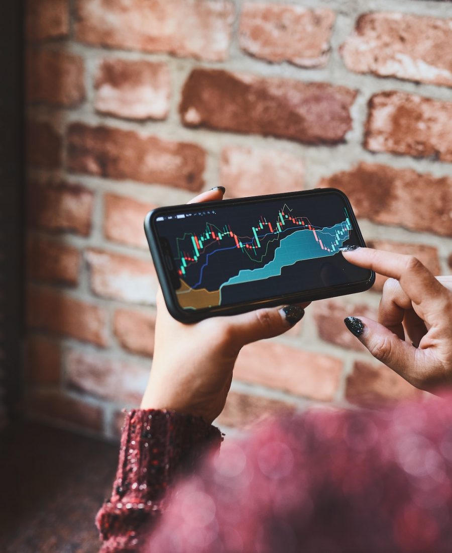 Woman investing trading on stock cryptocurrency market using investing application on smartphone