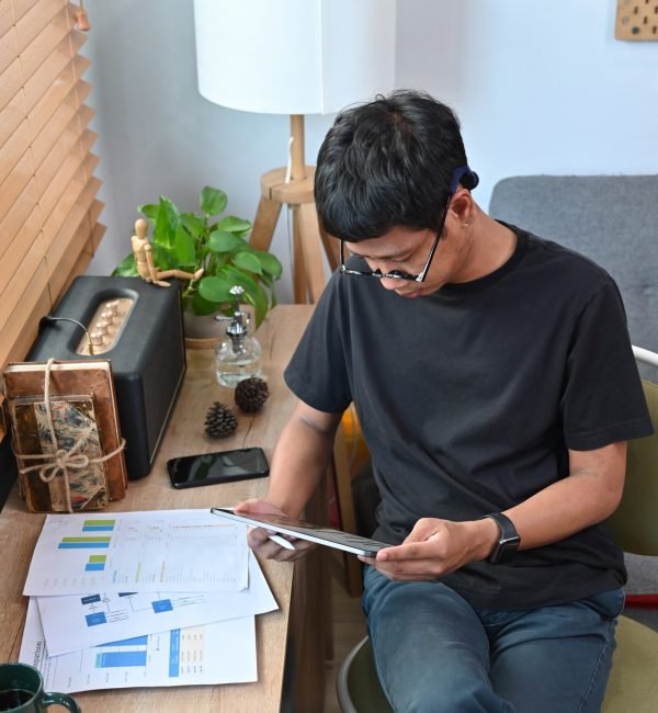 Young man analyzing graph stock market trading on digital tablet.