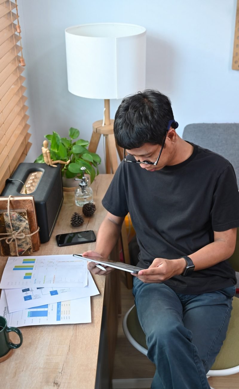 Young man analyzing graph stock market trading on digital tablet.
